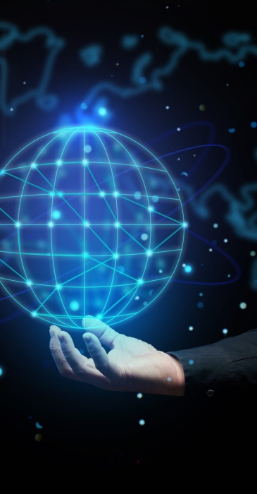 a man's hand holds a holographic globe on a dark blue background. Concept of globalization, world internet network, barrier-free