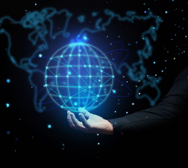 a man's hand holds a holographic globe on a dark blue background. Concept of globalization, world internet network, barrier-free